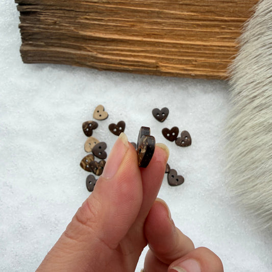 Jokainen 15 mm sydännappi on oma yksilönsä. Luonnonmateriaalin pienet sävyerot tuovat käsintehtyyn neuleeseen aitoa artesaanituntua.