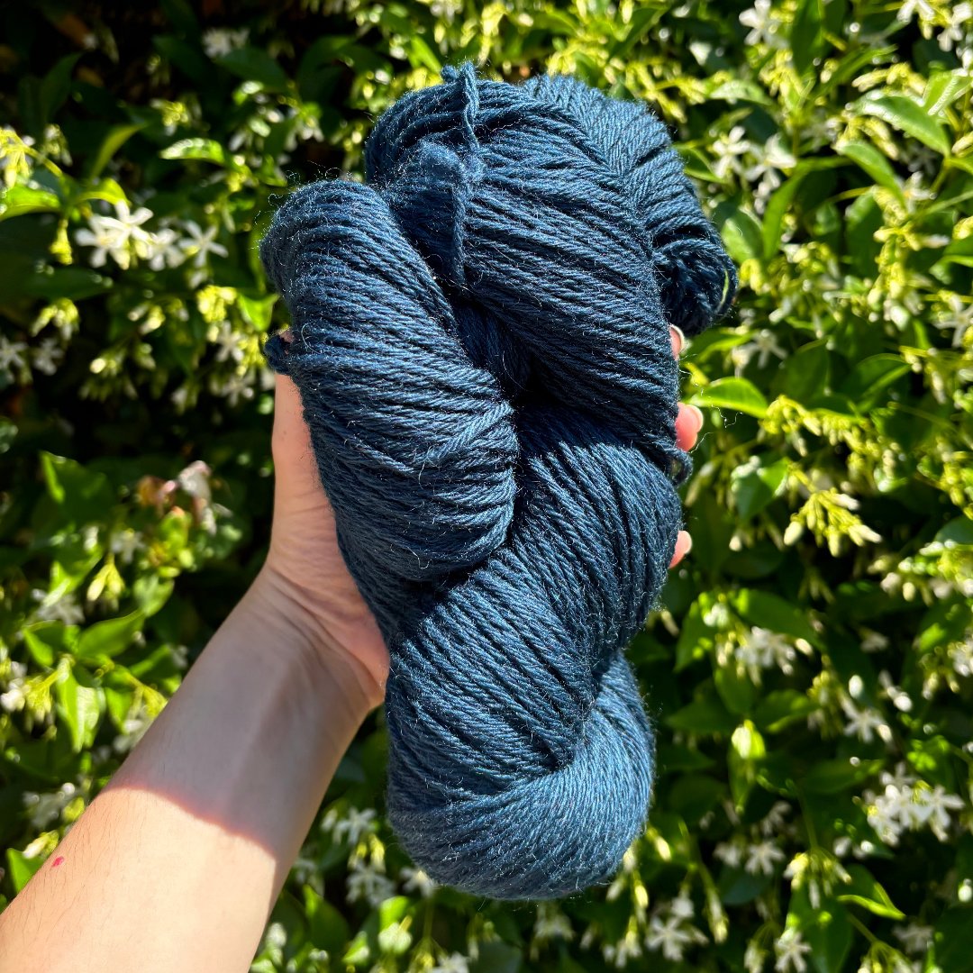 Blue merinowool yarn pictured outside.