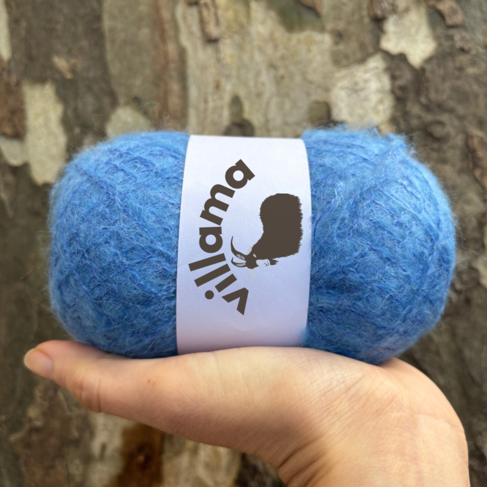 Light blue mohair yarn is pictured outside in a nature. Natural mohair yarn looks great in sunlight.